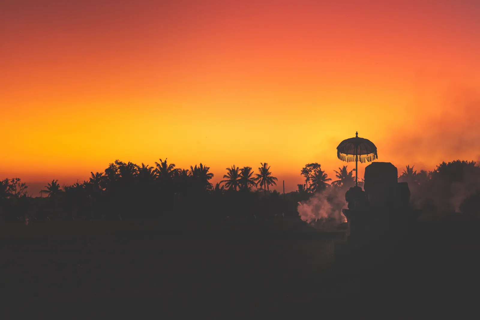 Tropical island seascape — Silhouette of palm trees at tropical sunset on Bali island.